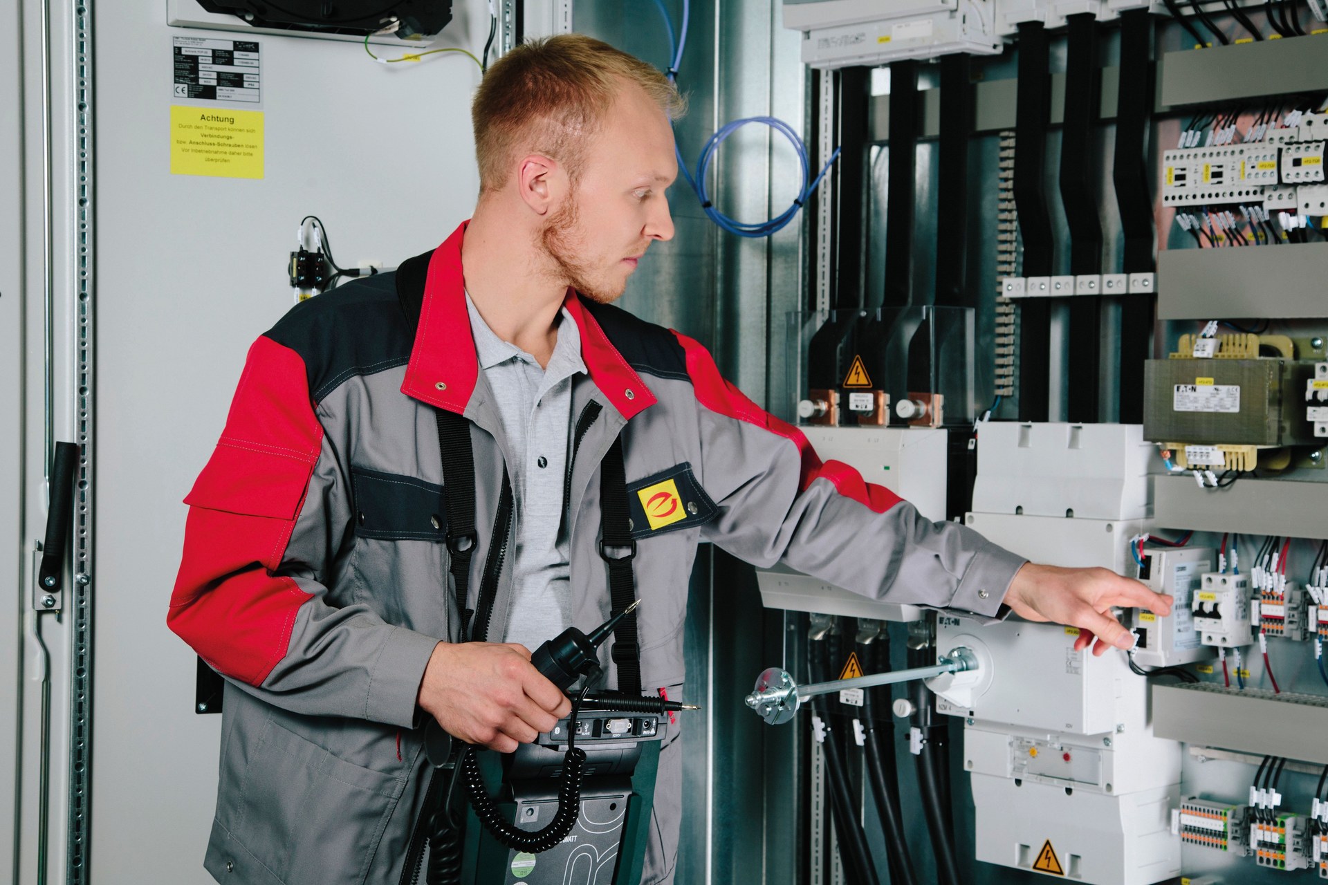 Elektrofachkraft kontrolliert eine elektrische Schaltanlage
