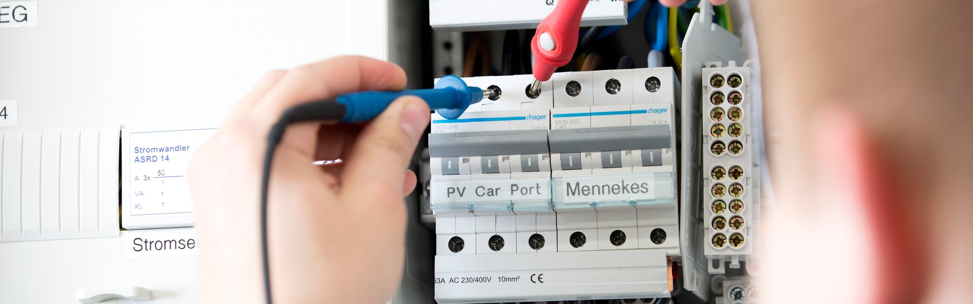 Elektrofachkraft misst an einer elektrischen Verteilung